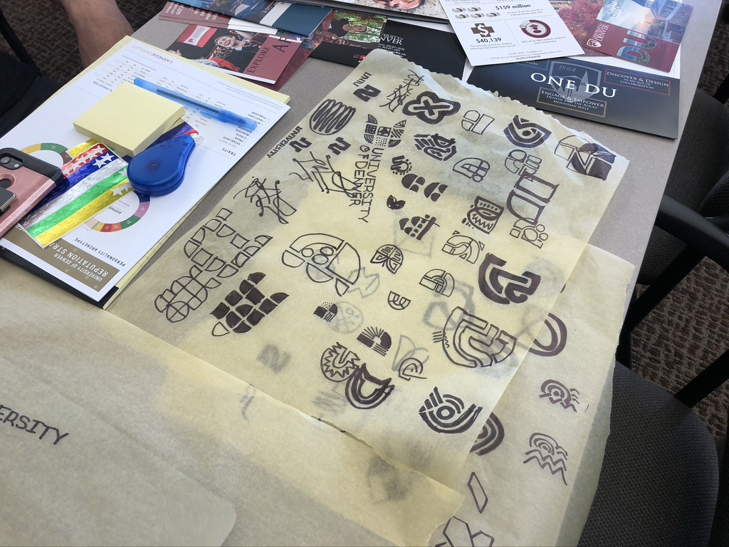 Design examples laid on a table with creative resources