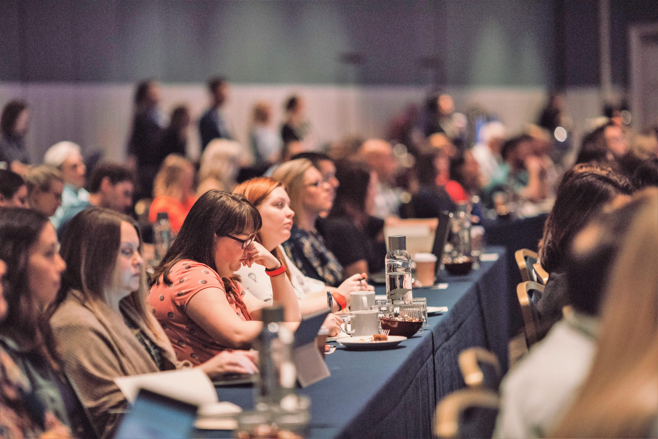 Image capturing attendees at the Carnegie Conference 2021, featuring a large audience in a professional setting, engaging with a speaker on stage.