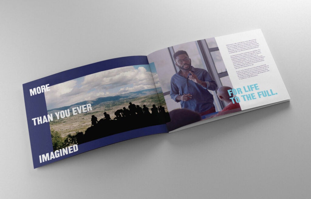 Open booklet with a group photo on one page and a man giving a presentation on the other page.