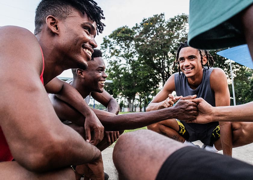 Young men grasping hands outdoors