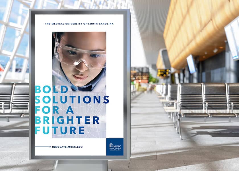 Poster in airport with a scientist’s face and text: “Bold solutions for a brighter future.”.