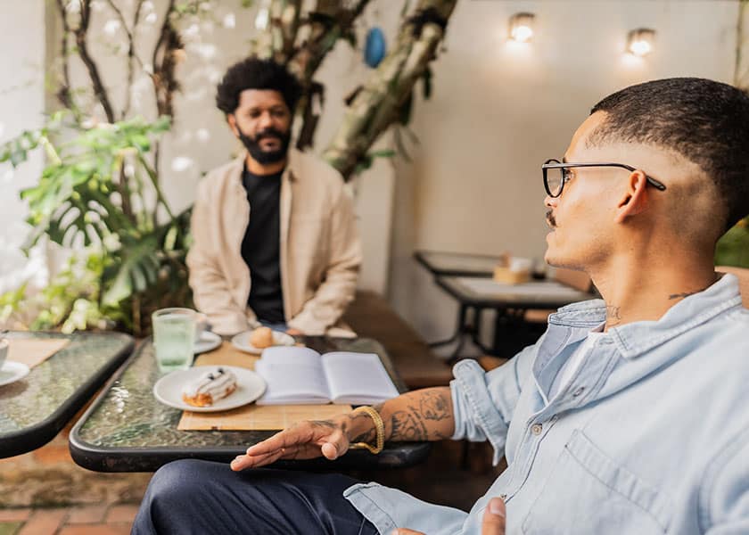 Two men sitting at a cafe talking