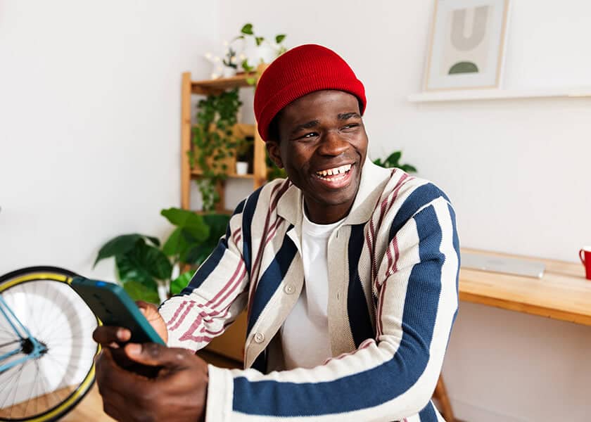 Man sitting indoors smiling with phone