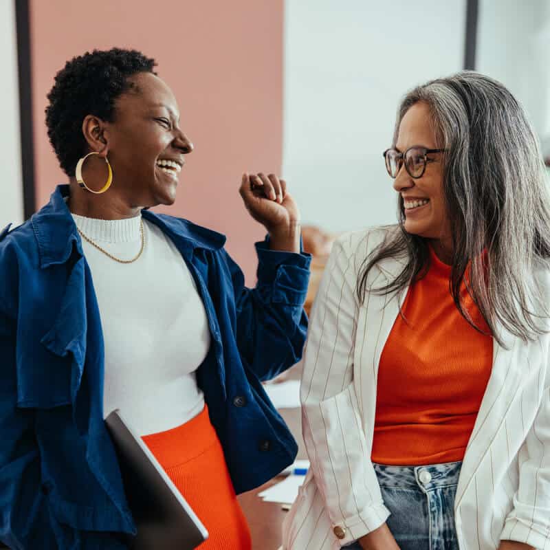 Two women smiling and chatting.