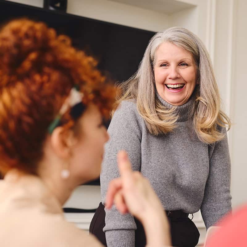 Two women smiling and talking