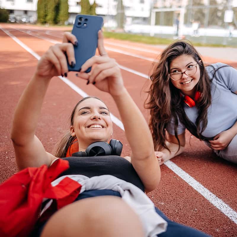 Two women on running track taking selfie