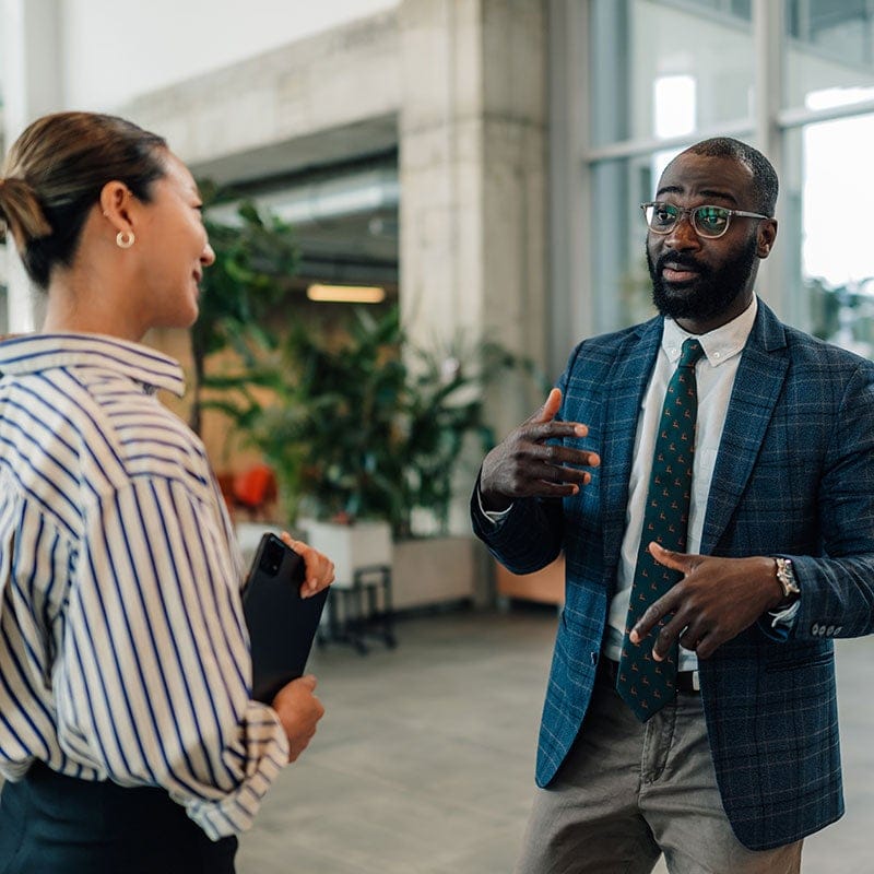 Woman and man talking in building lobby