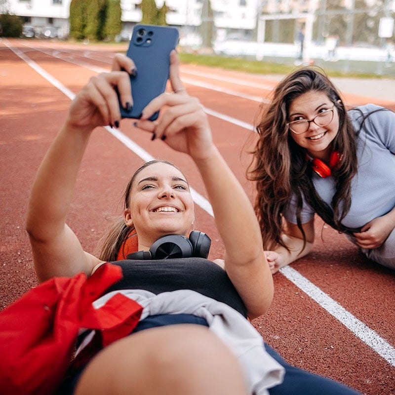 Two women on running track taking selfie