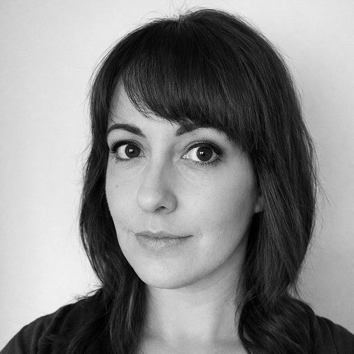 Black and white portrait of a woman with straight, shoulder-length dark hair and bangs, looking at the camera.