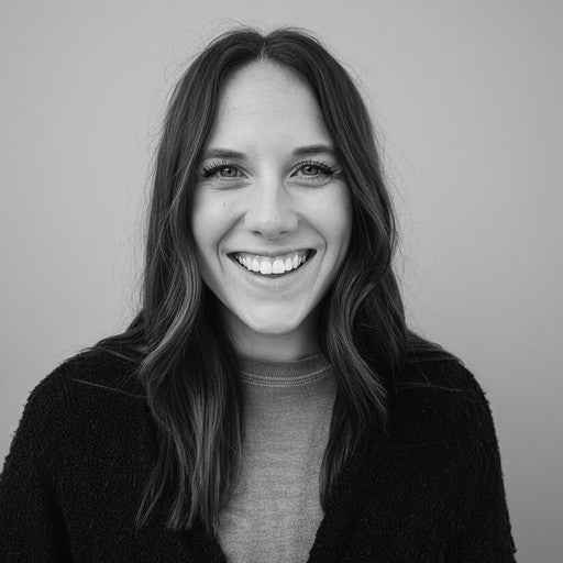 Smiling woman with long hair wearing a sweater, pictured in black and white against a plain background.
