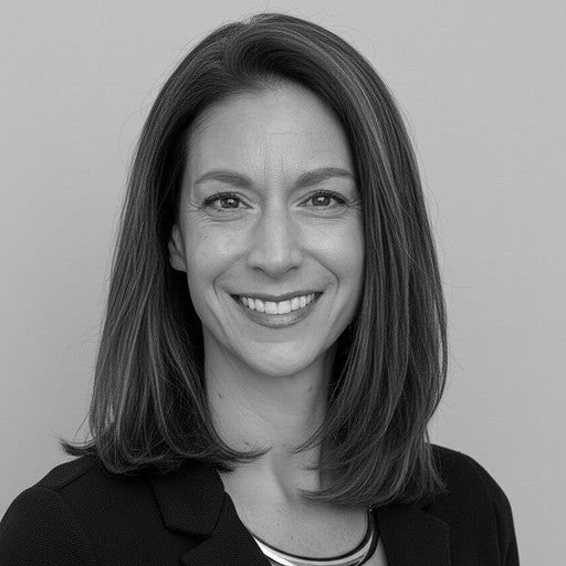 A woman with straight shoulder-length hair smiles, wearing a blazer, in a black and white portrait.