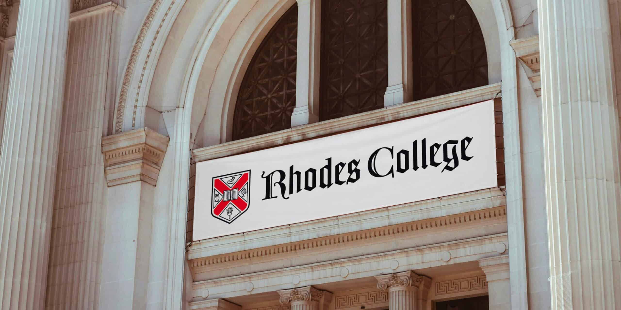 A banner reading "Rhodes College" hangs on the exterior of a large stone building with arched windows.