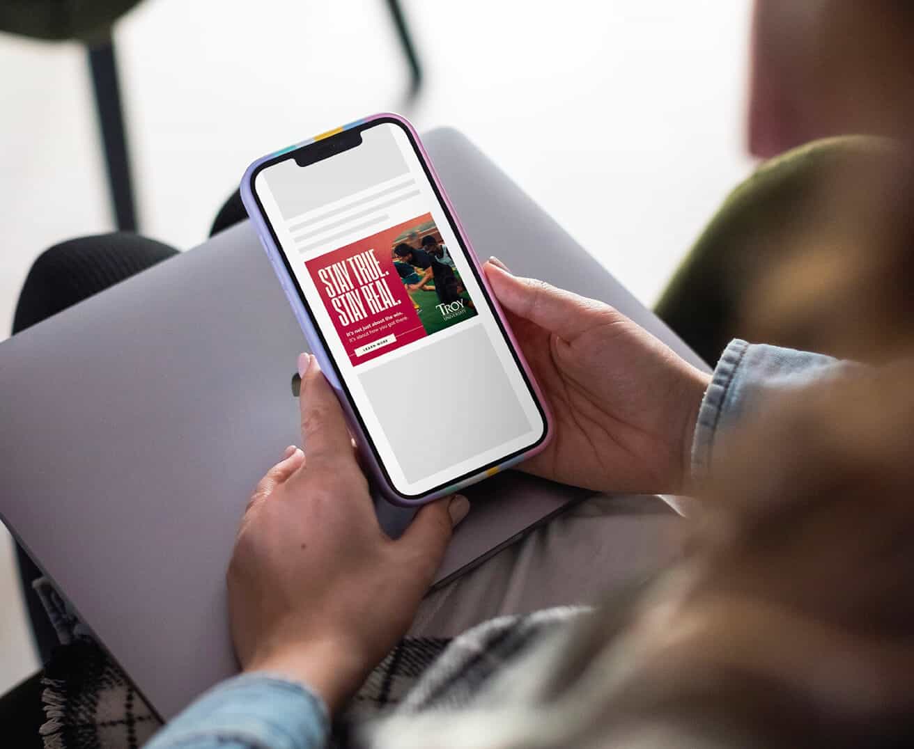 A person holds a phone displaying an online book titled "Stay Sexy & Don’t Get Murdered.