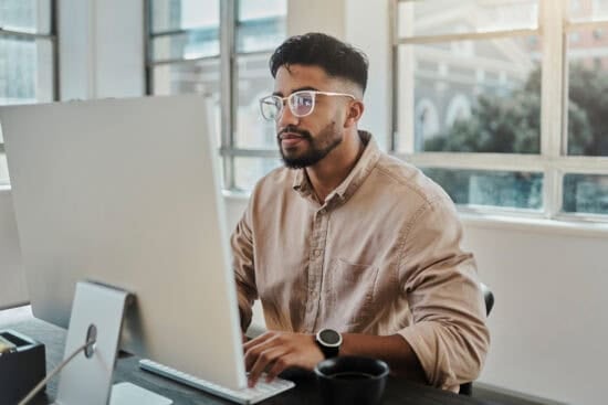 A man sitting at a desk using a computer.