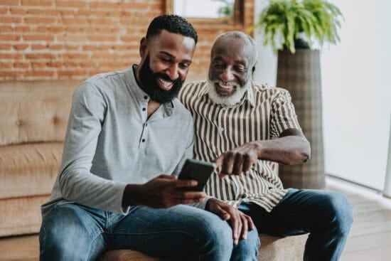Two men looking at a phone.