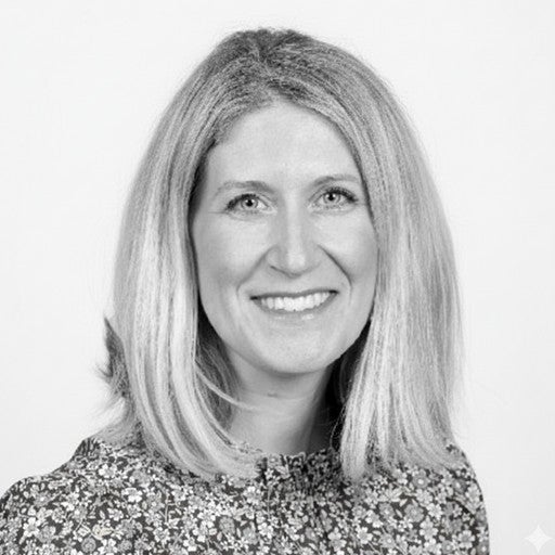 Smiling woman with shoulder-length blonde hair wearing a patterned top, in a black-and-white photo.